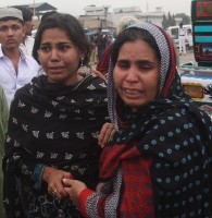 Relatives weep at the site of a burnt garment factory in Karachi, Pakistan were workers where locked in. An estimated 295 died. September 2012.  
