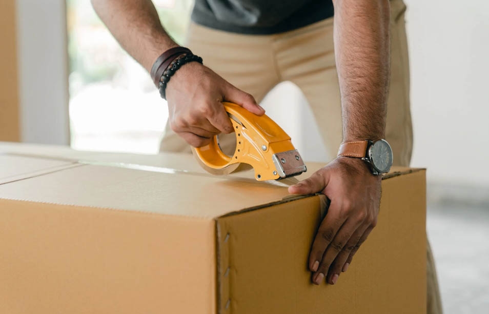 A man labeling and packing boxes after deciding between Toronto vs. Ottawa lifestyle.